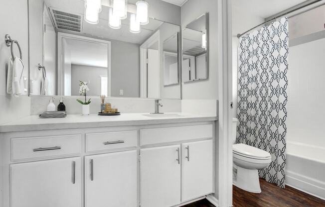 a white bathroom with a shower and a sink