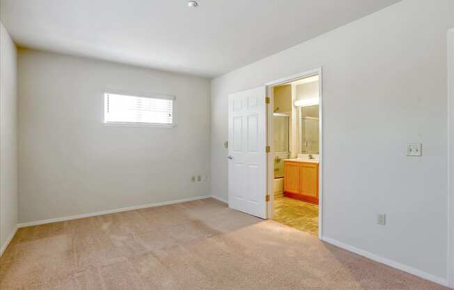 A room with a carpeted floor and a door leading to another room.