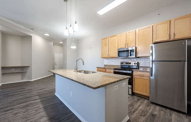 A kitchen with a granite countertop and stainless steel appliances.