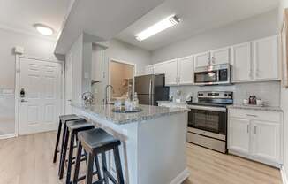 A kitchen with a bar area and stools.