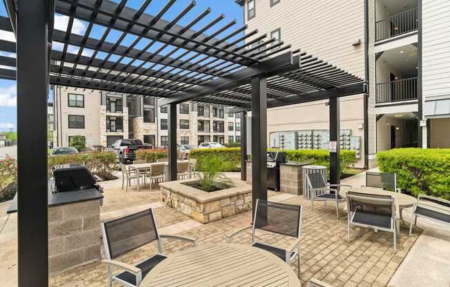A patio with a black pergola and benches.