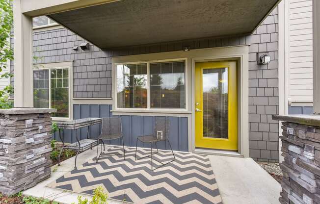 Outdoor Patio Area with Metal Chairs, Yellow Door, Stone Walls