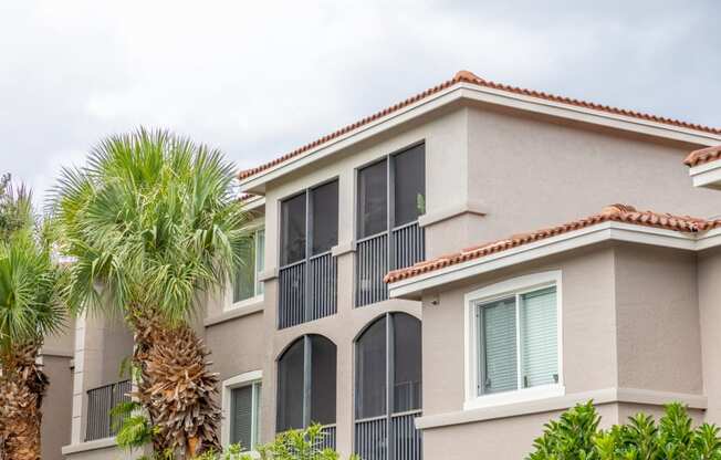 a condo building with a palm tree in front of it at Heritage Bay, Jensen Beach, 34957