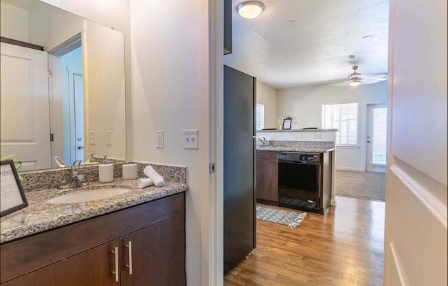 A kitchen with a granite countertop and a black refrigerator at Riverplace Apartment Homes, Independence, Oregon