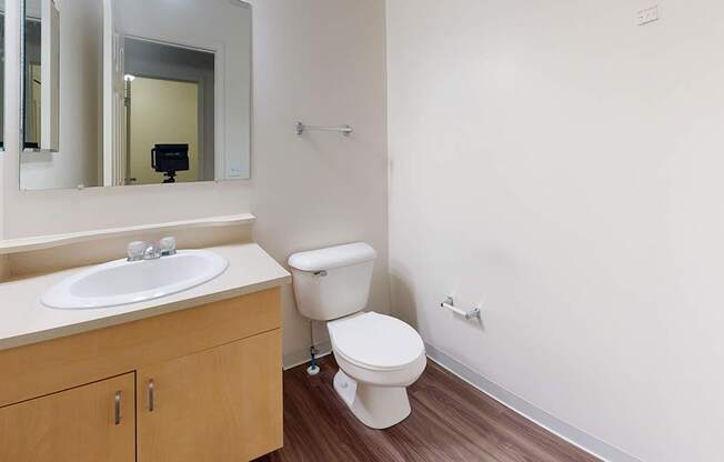 A white toilet sits next to a sink and mirror in a bathroom at Foxwood and The Hermitage, Michigan