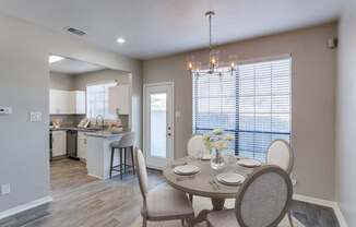 A dining room with a table set for four.