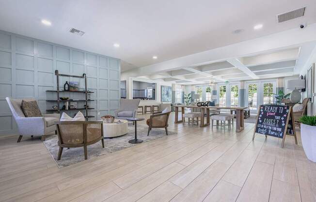 A room with wooden floors and a variety of seating options.at Spring Creek Apartments, Crestview, 32536