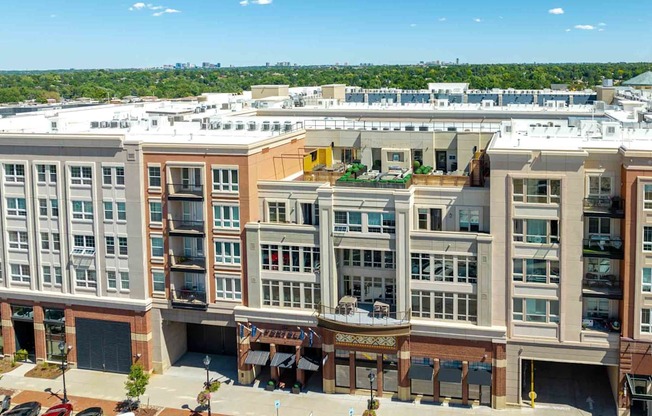 an aerial view of a large building with a parking lot in the foreground