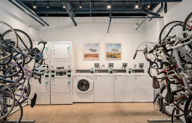 a laundry room with washing machines and bicycles hanging on the wall