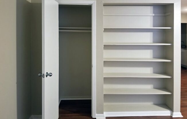 a closet with white shelves and a white door