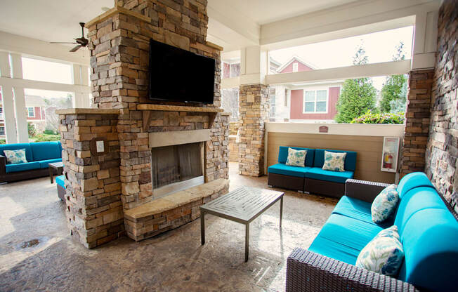 the living room has a large stone fireplace and blue couches