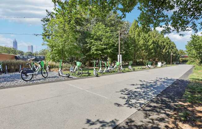 A row of bicycles are parked on the side of a road.