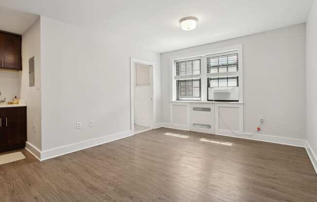 a bedroom with hardwood floors and white walls