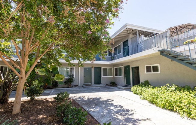 a house with a driveway and a tree in front of it