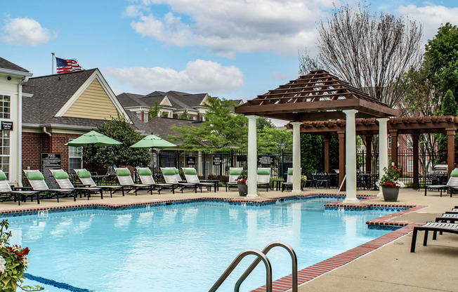 a swimming pool with lounge chairs and a pavilion