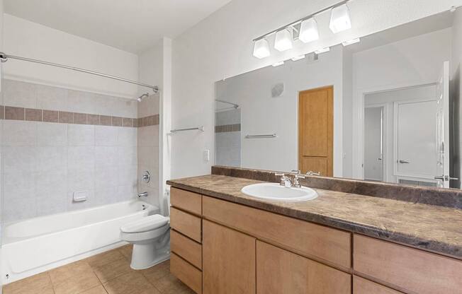 A bathroom with a sink, toilet, and bathtub.