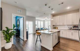 A modern kitchen with a large island and wooden floors.