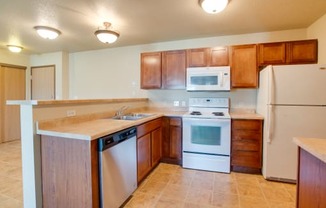 a kitchen with white appliances and wooden cabinets