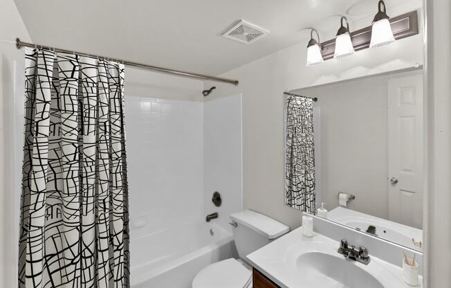 a bathroom with a shower curtain and a sink and a toilet