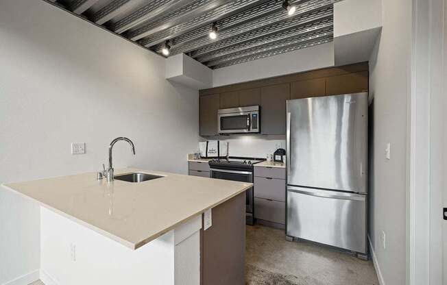 A kitchen with a sink, stove, and refrigerator.