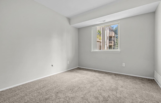 an empty room with carpet and a window