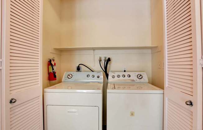 A white washing machine and dryer in a small laundry room.