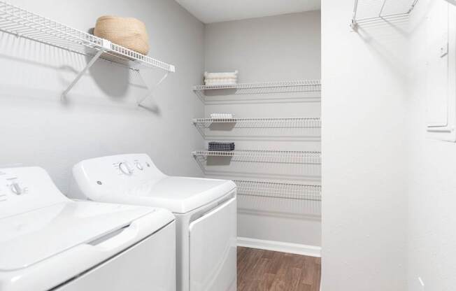 A white washing machine and dryer in a laundry room.