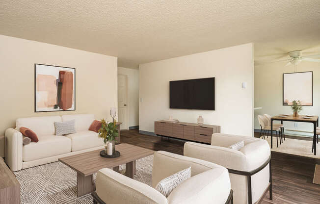 A living room with a white couch, a coffee table, and a television.