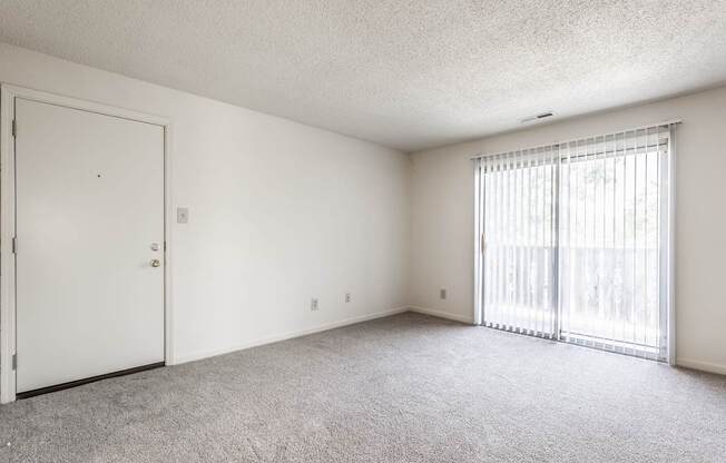 A room with a white door and a window with blinds.