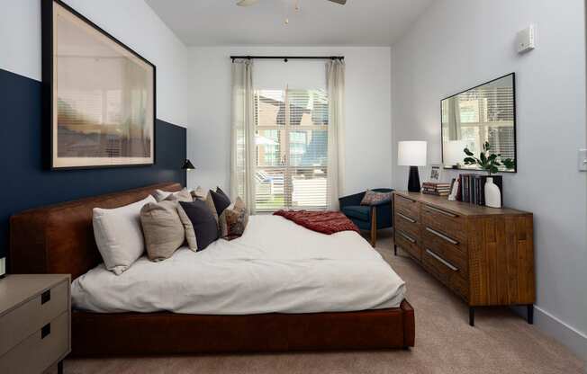 a bedroom with a bed and a dresser and a window