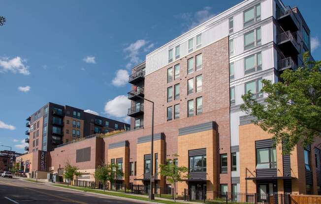 Exterior of Oxbo Urban Rentals looking building from the street with shrubbery lining the sidewalk.