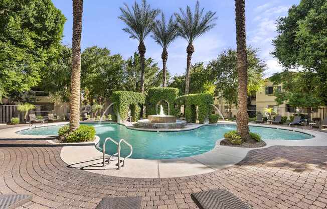 A pool surrounded by palm trees and bushes.