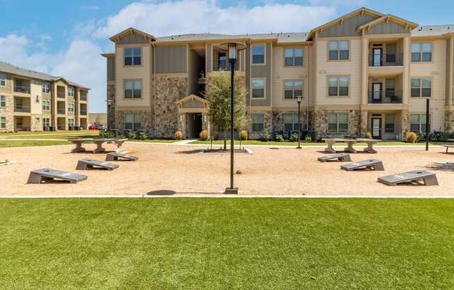 a picnic area with benches and a lamppost in front of an apartment building