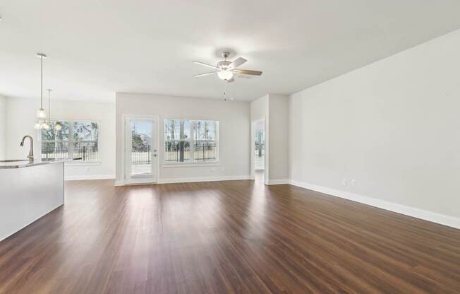 A room with a ceiling fan and a wooden floor.