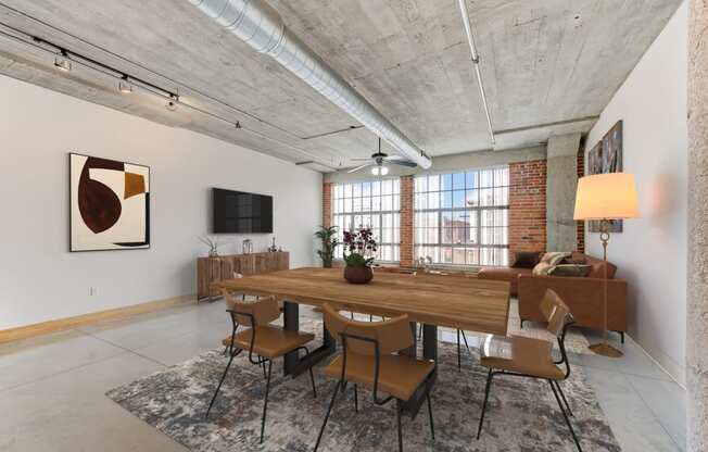 a living room with a large wooden table and chairs and a television