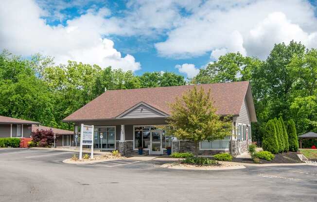 The Retreat at Indian Lake leasing office with a brown roof and a parking lot in front.