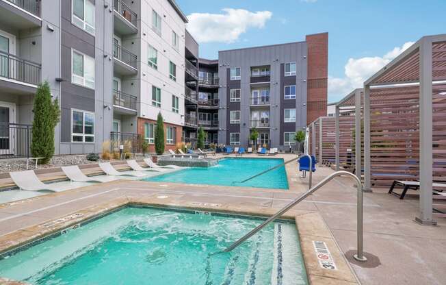 a swimming pool with an apartment building in the background