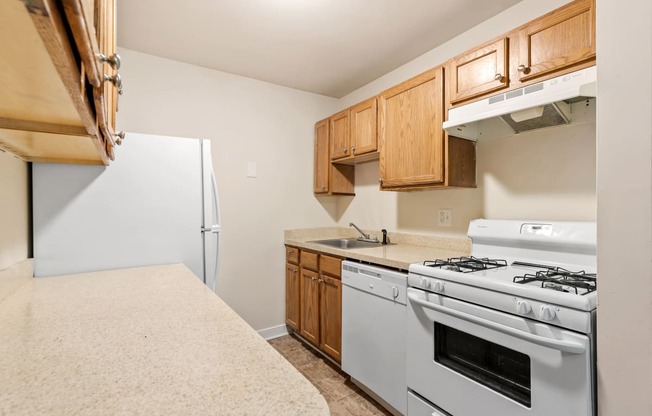 a kitchen with white appliances and wooden cabinets