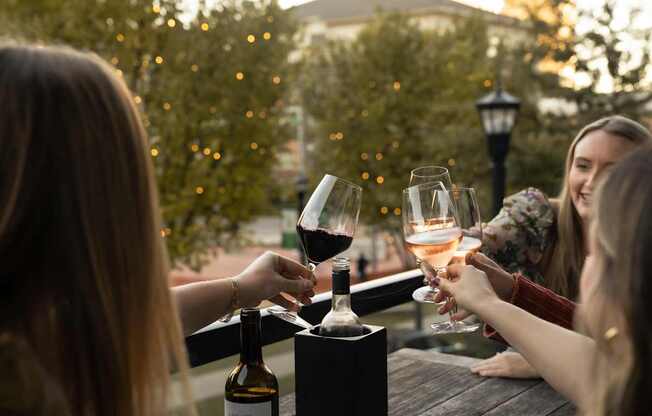 A group of people toasting with wine glasses at a table.