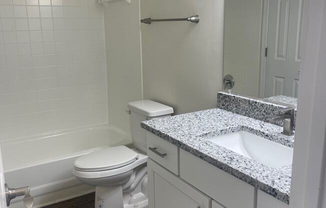 a bathroom with a toilet and a sink and a bath tub