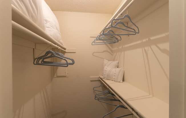 This is a photo of the bedroom walk-in closet in a 692 square foot 1 bed, 1 bath model aprtment at Cambridge Court Apartments in Dallas Texas