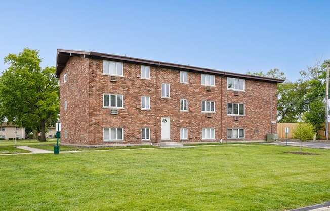 A brick building with a green lawn in front.