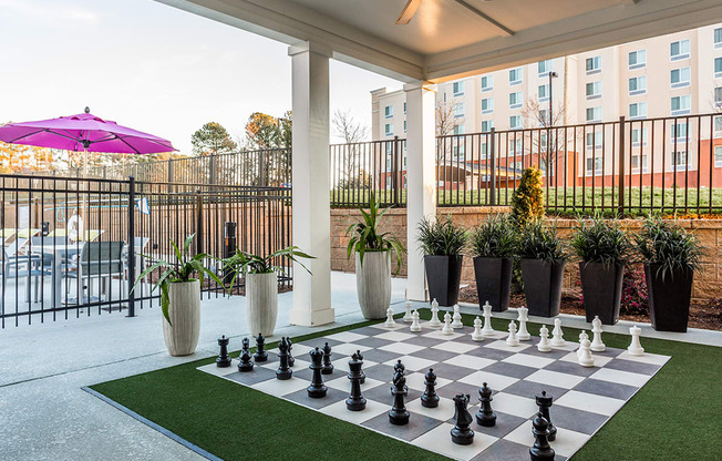 a chess board in therium of a hotel with plants and a building in the