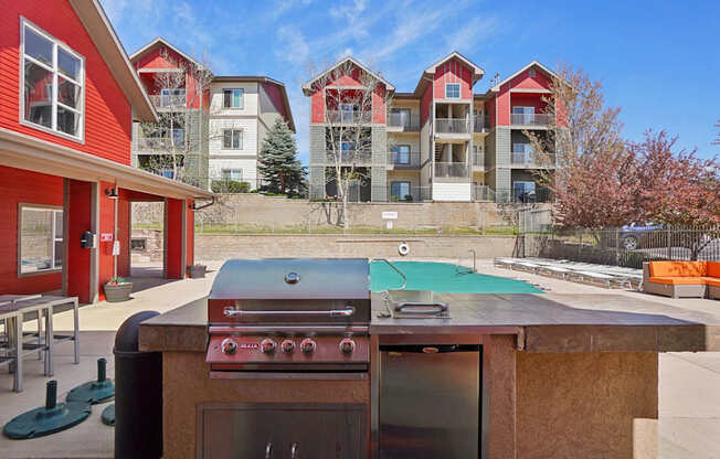 A red and white building with a pool table and a grill in front.