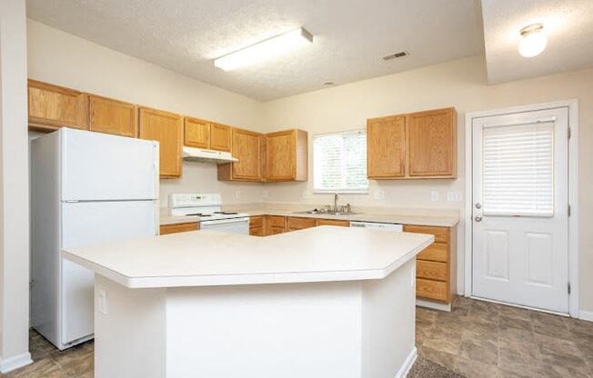 a kitchen with a white counter top and a refrigerator