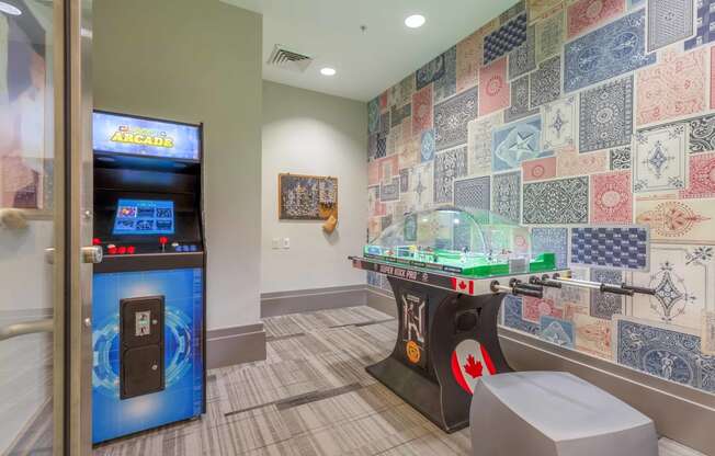 a game room with a foosball table and arcade games