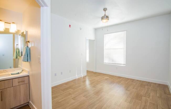 A bathroom with wooden floors and a white wall.