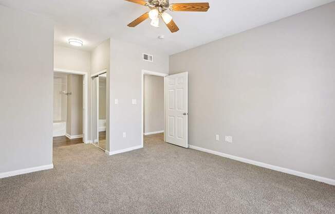 A room with a ceiling fan and carpeted floor.