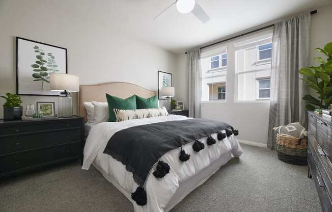 1, 2, & 3-BR Apartments In Riverside, CA - Lincoln Village - Bedroom With Comfortable Bedding, Carpet Flooring, Double Nightstands, 2 Windows, And Dark Wood Dresser
