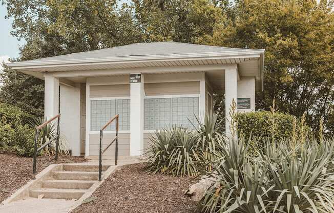 a small building with steps and plants in front of it